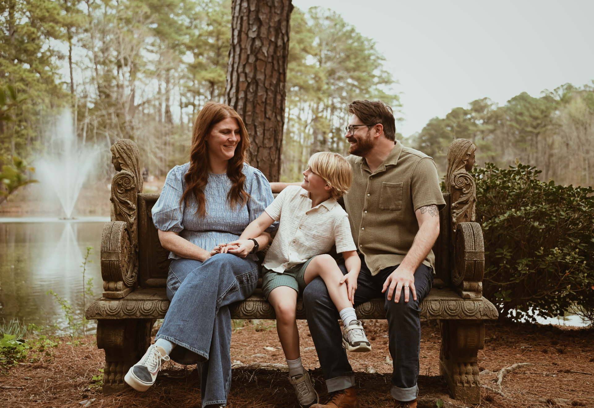 Family seated on an ornate bench beside the water
